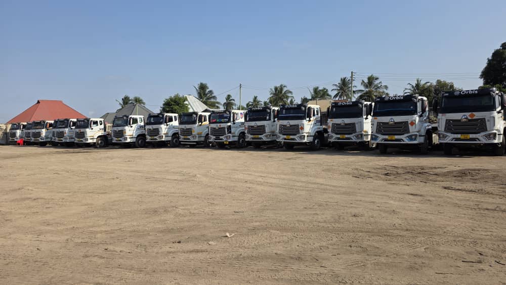 A long row of Orbis trucks parked in the yard